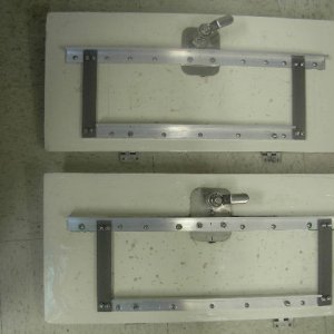 Cockpit hatch modification.  Angle brackets coupled to latch and hinges.  All components corrosion resistant.  Brackets preloaded to bend lid 1/8\" per Sea Skippers recommendation.  Bracket held with epoxy and wood screws.