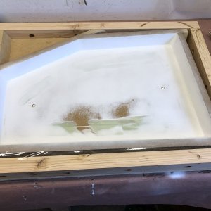 The mold for the port lid top is ready for laying up with 1708 and epoxy. There are several 1/2" holes in the bottom of this mold which are filled with wax. This gives a means to tap on the back of the mold with a 1/2" dowel to help pop the part free.