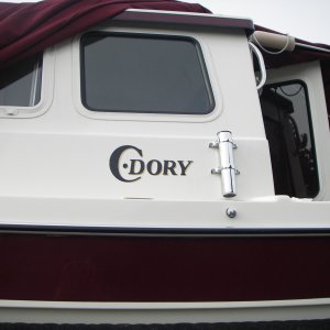 The storage cover is off just enough to get to the C-Dory logo spot for installation.  Note foam over the VHF antenna just above the boarding handle.