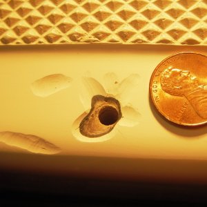 Penny for scale, showing grinding done to take out cracks in gel coat,  from screws moving and SS step guard digging into it.