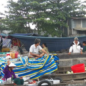 The boats are rafted up, generally based on the item they are selling.  Venders come by to sell them meals.