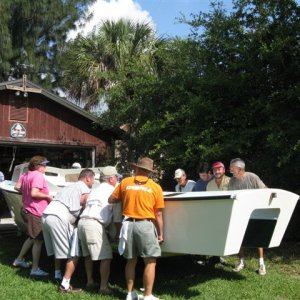(032 32)  Helping our neighbor move his homemade boat out of the workshop onto the trailer for engine install.