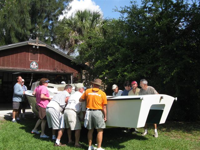 (032 32)  Helping our neighbor move his homemade boat out of the workshop onto the trailer for engine install.