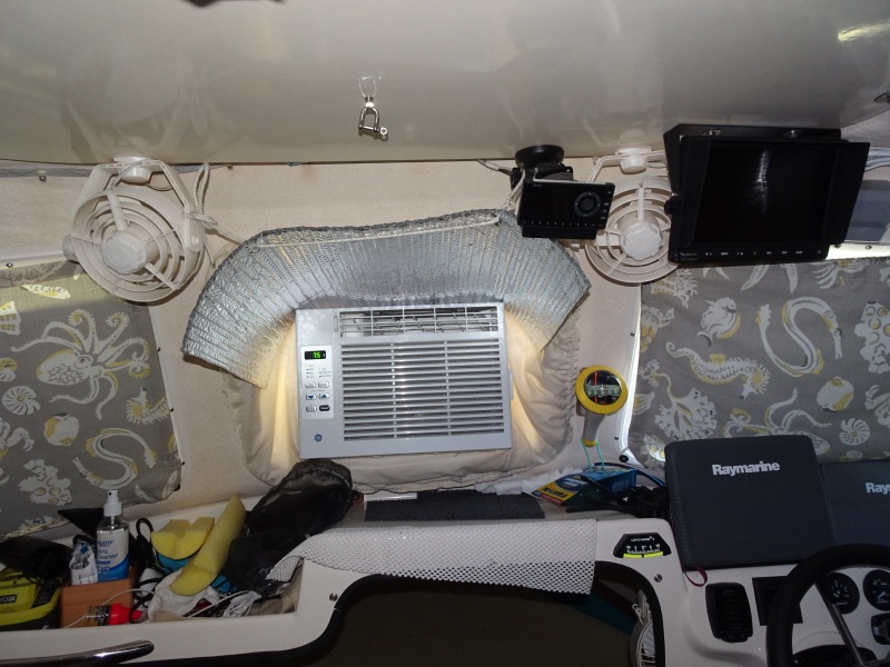 Air conditioner with "skirt in opening window. Above is Sirius radio, to right is rear view monitor with fan.  II am going to move monitor outboard and free up fan to be more versatile