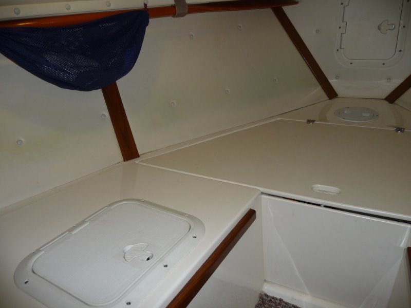 Cutty, Forward to Port.
Wooden boat paddle held up under port forward deck.
Access hatch to storage locker.