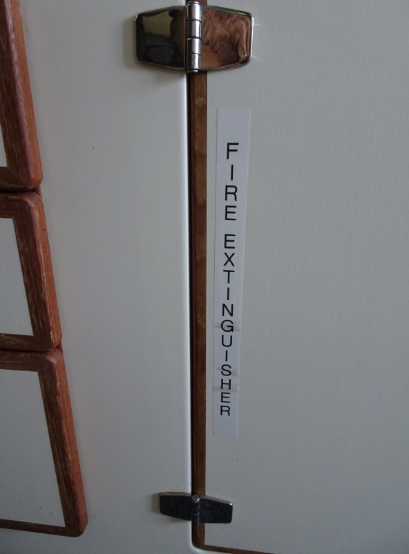 Denotation of galley fire extinguisher.  there is also a halogen "grease fire" extinguisher on top outboard of helm seat.