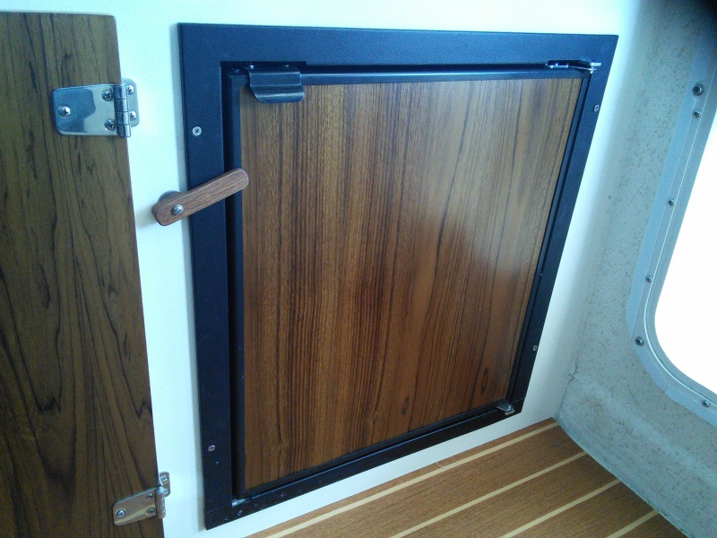 Dometic Tundra refrigerator.   Front door comes off and door panel can easily be removed to work on.  Varnished veneer panel has been slid in front of original plastic cover.