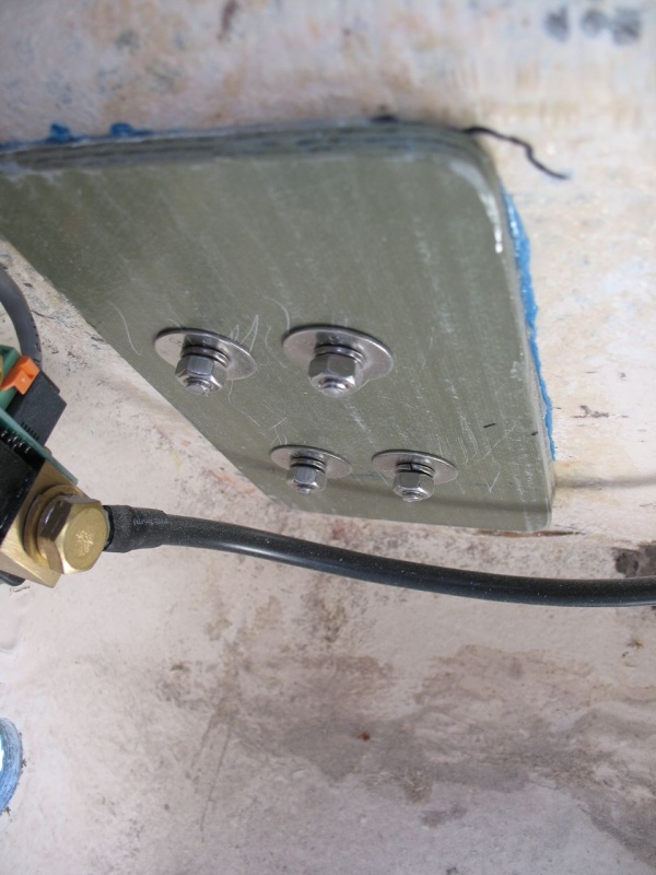 Fiberglass backing plate added to cleat.  First, core removed around fastener perimeters, then re-filled with thickened epoxy (hole in deck not enlarged; work done from below).  Next, backing plate set in place with "mush" of thickened epoxy.  Then holes redrilled through all and cleats re-bedded with butyl tape and re-fastened with new, 316 stainless fasteners.