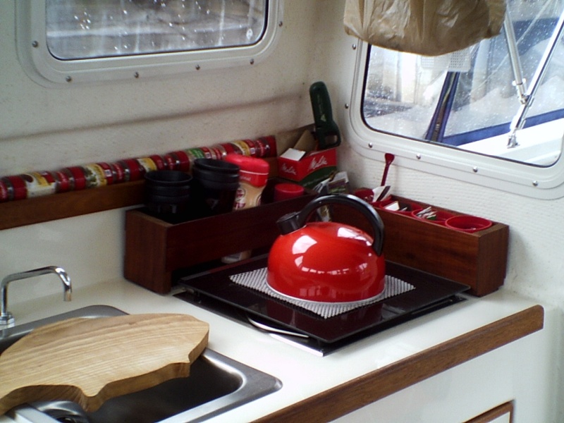 Galley area.  2 lift-out boxes made from 50 YO mahogany.  Back box holds coffee cups, etc.  Side box has small cups from Chuck E. Cheese which holds condiment packets form various fast food outlets.