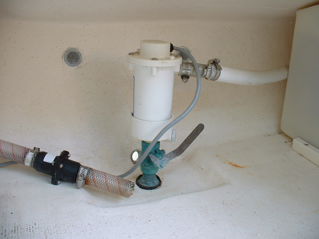 Here are some photos of the live bait well plumbed into the port laz by the dealer for the previous owner. The clear hose with check valve on the left is the intake for the manual bilge pump. This photo shows the bait pump with bronze through hull and valve.