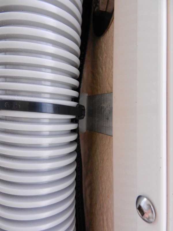 Here is what I used to keep the wiring (and Airhead vent hose) in the corner.  I made some aluminum tabs with tie-wrap anchors on the end.  I just pinched a few of these in the window frame - no holes!!