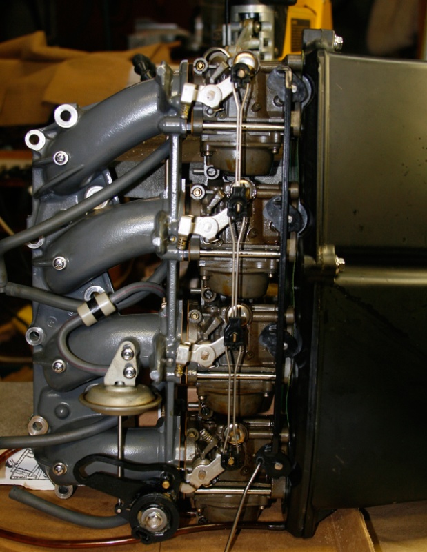 Intake manifold carbs Silencer Assy. You must remove this entire assembly to disassemble the carbs. It is easy to take out the nine bolts holding the intake to the head.