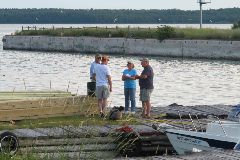 Ira discussing future of Lime Island with Janet, caretaker, and other fishermen.