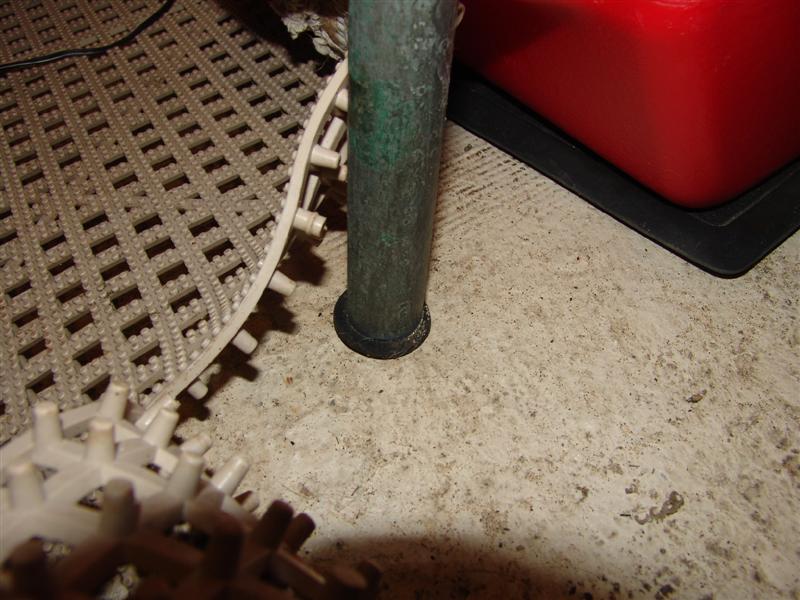 It rests in a rubber plug. Not bolted to floor.