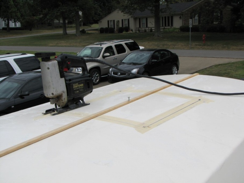 Masking tape to prevent splintering and wood strip attached to hold cut roof piece in place