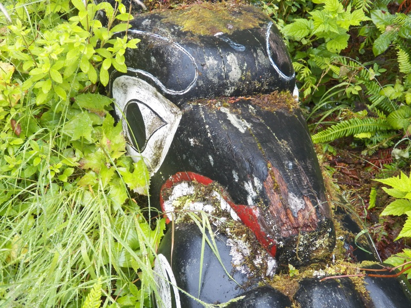 Older totems lay in the brush around the Big House.
