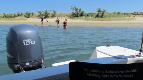 on the hook in West Neck Harbor on Shelter Island New York,Ginny paddle boarding on a borrowed board while Jess and Becky watch and swim. All three devil sisters in one photo