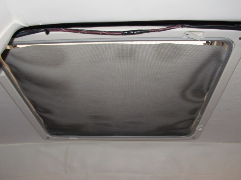 panel of heavy coated fabric between screen and hatch glass keeps the light out on those summer mornings.  Also keeps out the light from those bright dock lights at marinas.