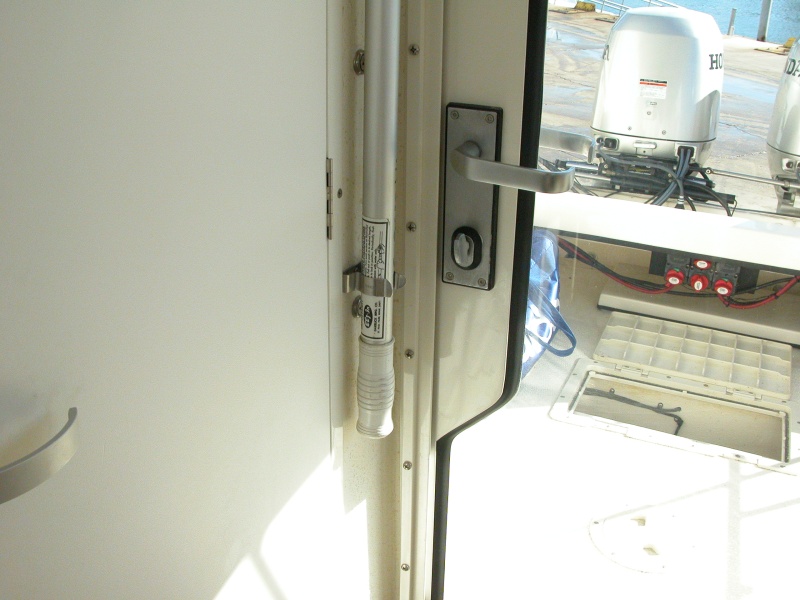 Plenty of clearence between boat hook and door handle when door is closed. Aft deck hatch is open to air out bildge after cleaning pump strainer.