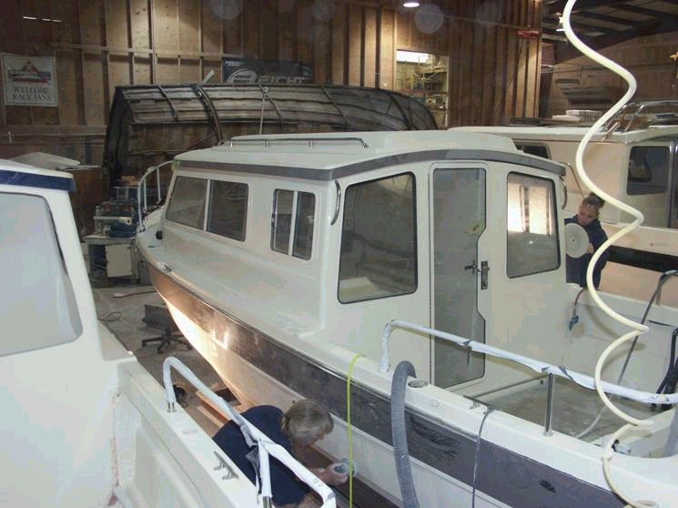 Port side work. Rear windows and door are now in place. Looks like some finish buffing on the lower port area.  3/15/04