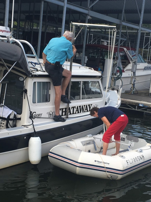 Ready to lift, Marie will come aboard into the cockpit and then go forward to help guide the dinghy onto the top.  The dinghy is hoisted bow aft, so the tubes will go under the radar arch, as it is rotated over the top of the boat with the davit.