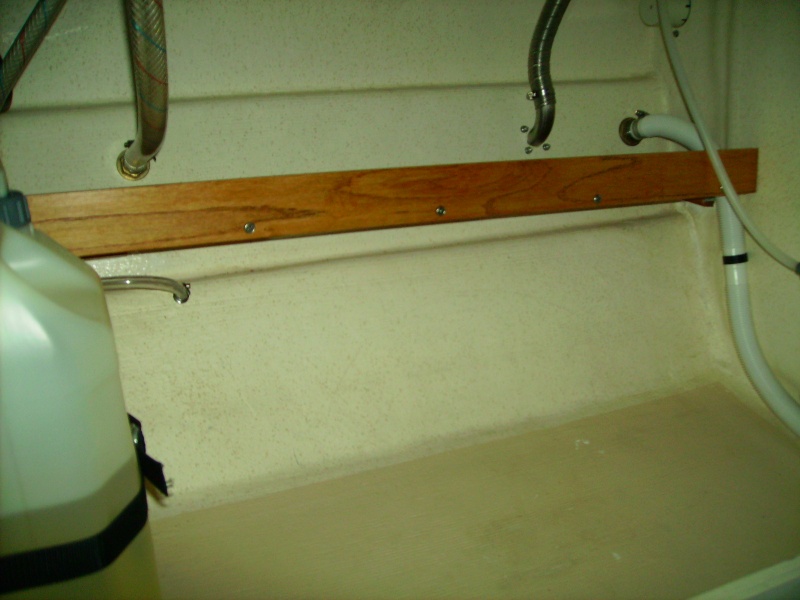 Shelf under sink.  7 1/2" oak with a 2" oak fiddle to keep stuff from sliding off.  Sits behind storage bin baskets, removed for photo.