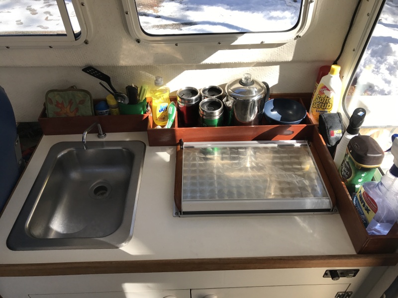 Stainless steel sink, faucet with foot pump, Wallas 95D diesel stove/heater and custom made wood storage racks.