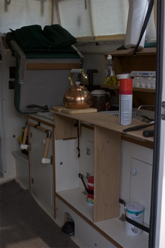 Starboard bed support provides useful counter space for galley. Drop down foot support shown in background
