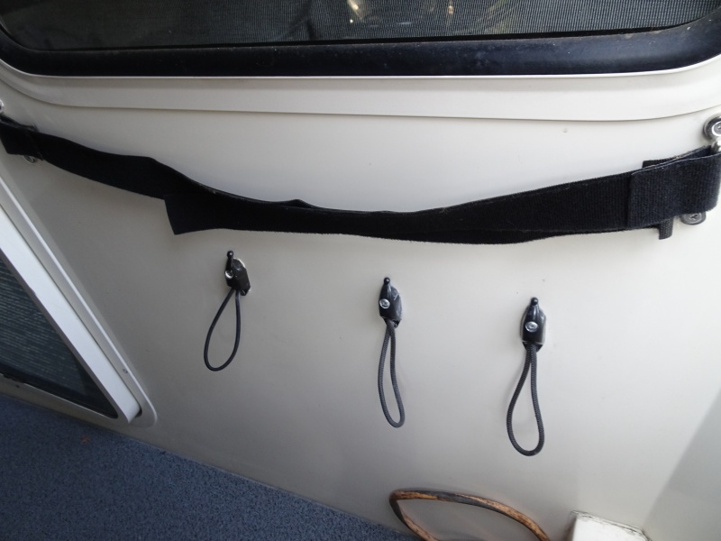 strap on top holds folding chairs in place.  Bungee cord holders for dock and extra docking lines.  One from bow, one from amidships cleat and one extra line.  Also in aft cockpit is a single similar bungee attachment for each stern line