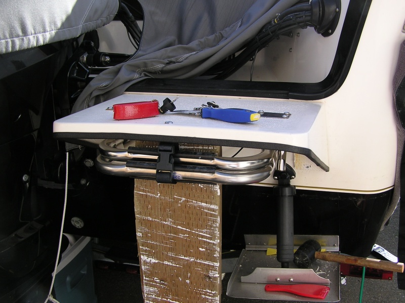 Swim step removal.  The tools; a sharpened putty knife, nylon spatula,heat gun, rubber mallet, 2X6 & a floor jack.  You can see the step actually bending under the load but not budging.