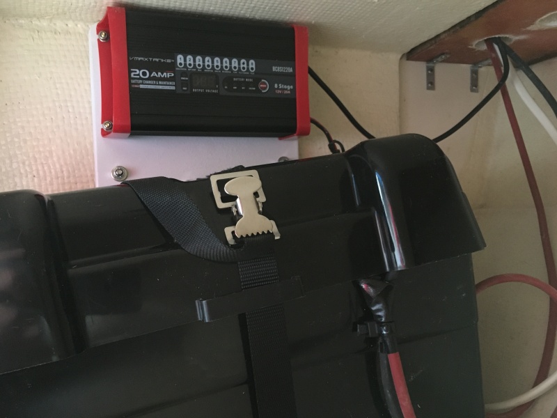 The house battery and charger are under the port seat.