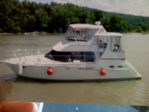 the original,"Misty Seas" 2000 carver, linda is standing at the aft cockpit side door waving and i'm at the helm, picture taken while cruising on the ohio river, mile marker 471.