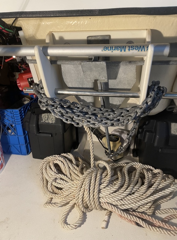 the stainless bar pulls out to instantly release all the chain with the rope coiled on the floor (Behind spare gas container and cooler)