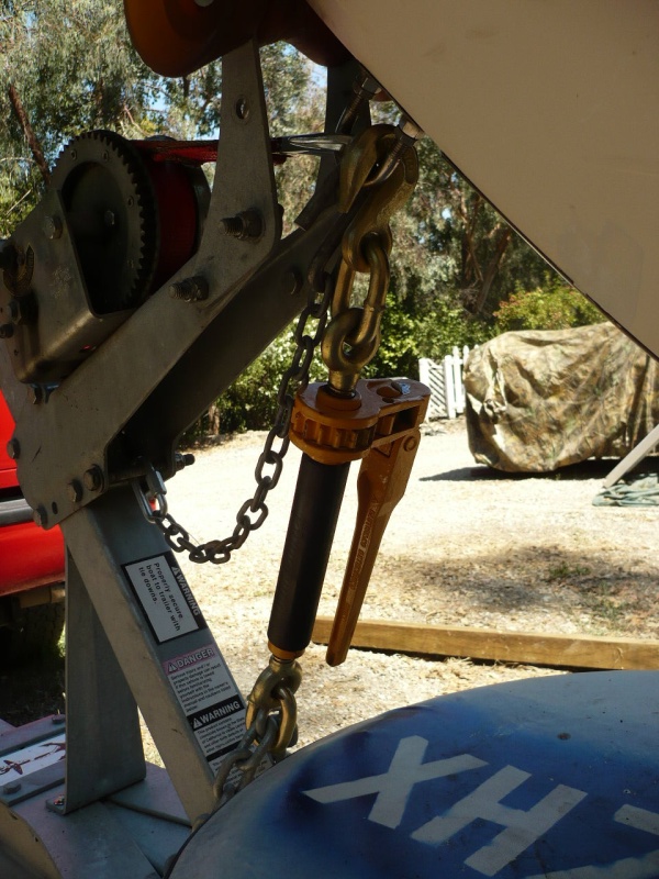 This is working out very well. It is so easy to put on and take off. Fasten the rear tie downs first, then this big guy tigtens both ends down tight (by pulling the front down, back up)and front end tight to both the bow stop and the front keel roller. You can just twist the shaft by hand until tight, then a crank or two on the handle. This is the ultimate turnbuckle. The item I used is called an SCC Quikbinder. I got mine at Tarpstop.com for 34.50 + ship. I'm sure it is avail. elsewhere. WL is 7100#.(35,500# avg. break) I think at that point it is probably stronger than the bow eye. I cut off the bottom hook with an angle grinder (wouldn't want this thing bouncing down the highway) Have gained enough confidence to consider adding the powerwinch 912 back on.