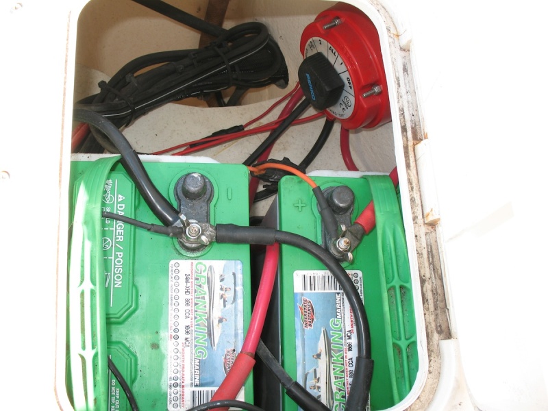 This photo shows the boat's original batteries (two Group 24 flooded cell batteries) and switch (1-2-Both-All). Many leads going right to battery terminals, no buses, just not very tidy.  Battery trays were screwed right into core, original (leaky) hatch lids, etc.