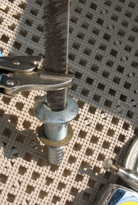 "Tool" for removing through hull since I didn't have the proper tool on hand.  Old junk file to catch on the "ears" inside the through hull and vise grips to hold file.
