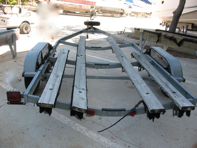 Trailer, as purchased.  Boat was stored indoors on a rack; trailer was left outside to fend for itself.  I should post an "after" photo as it is much improved now!  New bunks and carpet, new "half moons" on the fenders, new disc brakes, new actuator, new rollers, new winch and strap, new tires, new taillights and wiring, new spare.  Or to put it another way: Same frame ;)