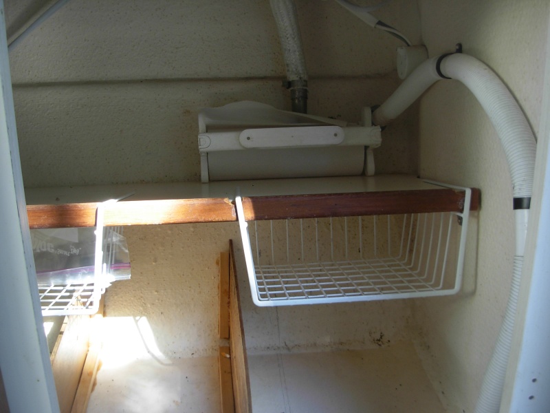 Under sink storage.  These baskets are from a hardware store storage supplies.  They are made to slide on to a shelf.  I had to cut notches in the facing of the shelf to get them to fit.  
In the bottom I epoxied vertical "walls" to divide the storage.  We found this still offers a lot of flexibility. The roll of paper towels on a dispenser on the shelf in front of the two hose outlets is an eye distraction.  It goes in its base holder above a window.