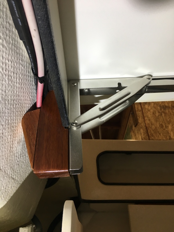 Underneath view. The hinges are screwed to the wood supports with three screws, two through the fiberglass crossmember.
