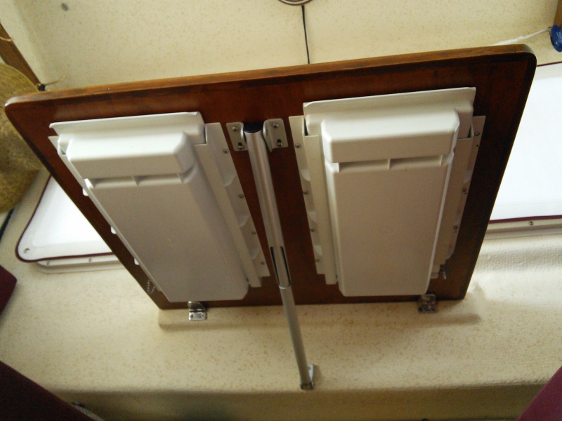 Underside of drop-down table.   A slide out plastic drawer has been installed on each side of the support bracket.  A small thru-bolt is inserted in the track and drawer towards the back of each drawer when not in use to keep it from opening and spilling the contents when underway or while trailering.