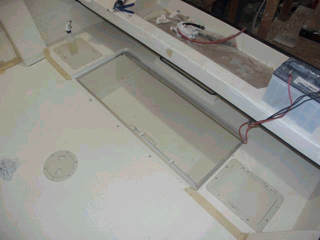 View of fish box (lid removed) and side storage areas (these access lids were too small and are to be replaced with larger units).  Les thinks that maybe the batteries might fit below deck in these areas (that's Les, always thinking).  A close examination reveals the macerator pick-up tube (near side of box).
