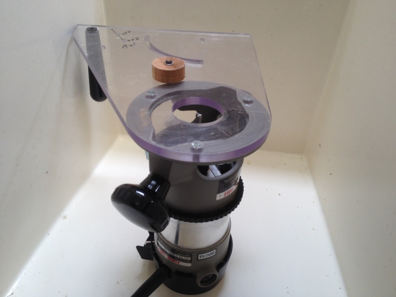 We\'ll use a router with a spiral upcut bit to make the hole. Luckily I have a multi-purpose router base and with a wooden plug to fit the existing hole, it will guide the circle cut.